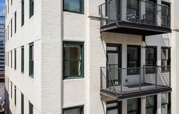 a white brick building with two balconies on the side of it